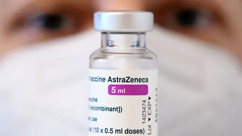 18 March 2021, Austria, Vienna: A health worker looks at a vial of AstraZeneca's coronavirus vaccine at a vaccination centre. The European Medicines Agency deems the use of AstraZeneca's Covid-19 vaccine safe despite blood clot reports. Photo: Helmut Fohringer/APA/dpa