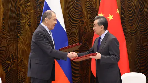 HANDOUT - 23 March 2021, China, Guilin: Russian Foreign Minister Sergey Lavrov (L) shakes hands with Chinese Foreign Minister Wang Yi as they exchange signed documents during a signing ceremony after their meeting. Photo: -/Russian Foreign Ministry/dpa - ATTENTION: editorial use only and only if the credit mentioned above is referenced in full