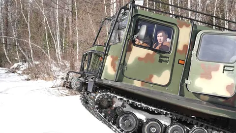 HANDOUT - 21 March 2021, Russia, Siberian Federal District: Russian President Vladimir Putin drives an all-terrain vehicle as he visits Taiga forest in Russia's Siberian Federal District. Photo: -/Kremlin/dpa - ATTENTION: editorial use only and only if the credit mentioned above is referenced in full