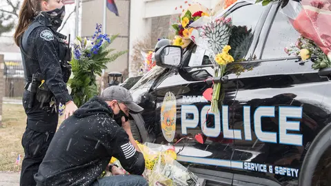 23 March 2021, US, Boulder: Policemen mourn near the vehicle of police officer Eric Talley, who was among the 10 people killed by a gunman during a mass shooting at the King Soopers grocery store. Photo: Pj Heller/ZUMA Wire/dpa