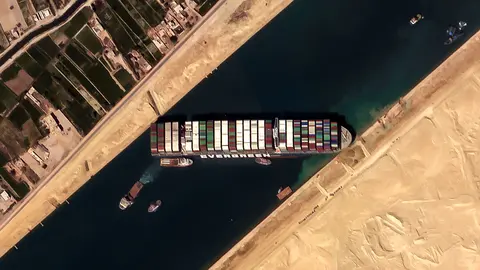HANDOUT - 26 March 2021, Egypt, Suez: A satellite image provided by the European Space Imaging on 26 March 2021 shows the 'Ever given', a container ship operated by the Evergreen Marine Corporation, is currently stuck in the Suez Canal. The state-run Suez Canal Authority (SCA) announced that nearly 17,000 cubic meters of sand have been dredged around the ship after navigation through the Suez Canal has been temporarily suspended until the full refloating of the Panamanian massive cargo vessel which ran aground on Tuesday in the southern end of the Suez Canal and blocked the traffic in both directions. The ship turned sideways in the Canal, while on the route from China to Rotterdam, due to reduced visibility that resulted from a dust storm hitting the area, according to SCA. Photo: -/European Space Imaging/dpa - ATTENTION: editorial use only and only if the credit mentioned above is referenced in full