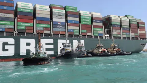 HANDOUT - 28 March 2021, Egypt, Suez: Tugboats take part in the refloating operation carried out to free the "Ever Given", a container ship operated by the Evergreen Marine Corporation, which is currently stuck in the Suez Canal. The pressure is mounting on Egypt to dislodge the Panama-flagged massive container ship which has blocked the Suez Canal since Tuesday, as more shipping firms are rerouting their vessels away from the waterway. Photo: -/Suez Canal Authority/dpa - ATTENTION: editorial use only and only if the credit mentioned above is referenced in full