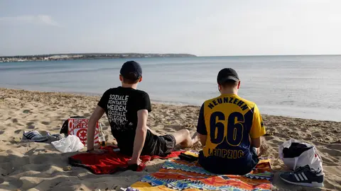 27 March 2021, Spain, Palma: German tourists from Leipzig Lucas and Marcel relax on the beach of Arenal. Photo: Clara Margais/dpa