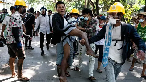 FILED - 19 March 2021, Myanmar, Yangon: Demonstrators carry a wounded man during clashes at a protest against the military coup and the detention of civilian leaders. Photo: Aung Kyaw Htet/SOPA Images via ZUMA Wire/dpa