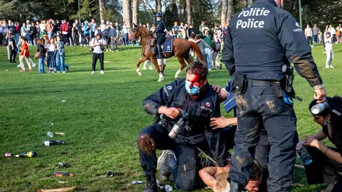 01 April 2021, Belgium, Brussels: An injured policeman arrests a protester at the Bois de La Cambre - Ter Kamerenbos as Brussels local police start the evacuation of the Park. Photo: Hatim Kaghat/BELGA/dpa