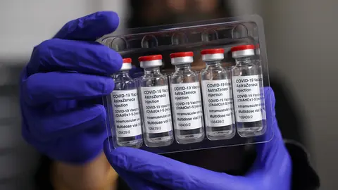 09 April 2021, United Kingdom, London: Pharmacist Asha Fowells holds vials of the Oxford/AstraZeneca coronavirus vaccine at Copes Pharmacy and Travel Clinic in Streatham, south London. Photo: Yui Mok/PA Wire/dpa