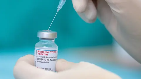 16 April 2021, North Rhine-Westphalia, Bielefeld: A nurse draws up the vaccine of the manufacturer Moderna against the coronavirus with a syringe, at the vaccination centre in the workshop for people with disabilities. Photo: Friso Gentsch/dpa