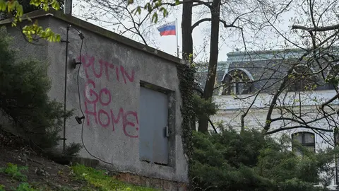 22 April 2021, Czech Republic, Prague: The Russian flag waves on top of the Russian embassy in Prague near a construction with graffiti ready "Putin, Go Home". Photo: Kamaryt Michal/CTK/dpa