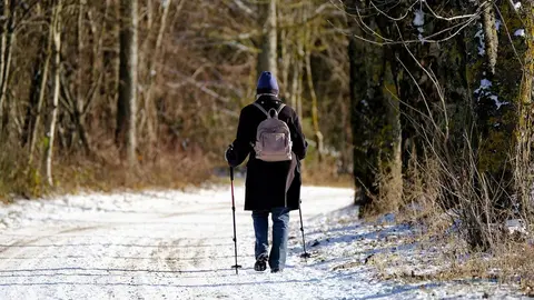 A woman walking on a snowy road. Photo: Pixabay.