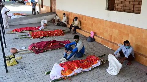 27 April 2021, India, Prayagraj: Family members wait with bodies of their relatives who died of Covid-19 to be cremated at an electric crematorium in Prayagraj. India hit record numbers of Covid-19 infections worldwide for the sixth day running on Tuesday, as health systems buckled under the pressure, and shortages of medical oxygen and hospital beds led to more deaths. Photo: Prabhat Kumar Verma/ZUMA Wire/dpa
