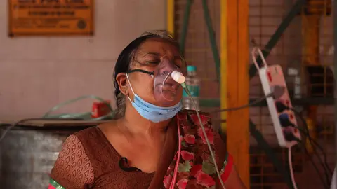 01 May 2021, India, New Delhi: A Covid-19 patient who is suffering from breathing difficulty breaths with the help of an oxygen mask outside a Gurudwara in New Delhi. India hit record numbers of Covid-19 infections for the sixth straight day as health system buckled amid shortage of medical oxygen and hospital beds. Photo: Naveen Sharma/SOPA Images via ZUMA Wire/dpa