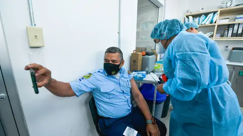 05 May 2021, El Salvador, San Salvador: A firefighter takes a selfie while a health worker administers him the second dose of the Chinese Corona vaccine Coronavac. Photo: Camilo Freedman/SOPA Images via ZUMA Wire/dpa