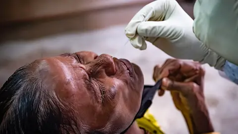 A health worker takes a nasal swab from a woman for a coronavirus test at a testing centre in Kolkata. Photo: Dipayan Bose/dpa.