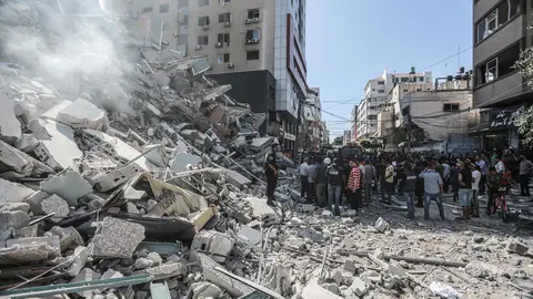 14 May 2021, Palestinian Territories, Gaza City: Palestinians inspect the remains of Al-Jalaa tower, which housed several media outlets including The Associated Press and Al Jazeera, after it was hit by an Israeli airstrike amid the escalating flare-up of Israeli-Palestinian violence. Photo: Mohammed Talatene/dpa