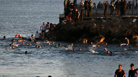 17 May 2021, Spain, Ceuta: Spanish civil guard officers try to stop people from Morocco from entering the Spanish enclave of Ceuta. Photo: Antonio Sempere/EUROPA PRESS/dpa