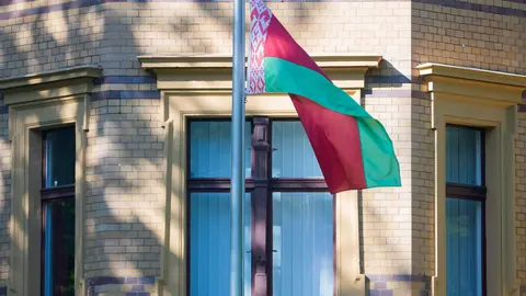 24 May 2021, Berlin: The national flag of Belarus flies in front of the Belarusian embassy in Berlin. The EU has strongly condemned the forced landing of a scheduled flight by Belarusian authorities in Minsk and held out the prospect of sanctions against those responsible. Belarusian authorities dispatched a fighter jet to force a Ryanair flight to divert to Minsk, where Roman Protasevich, a Belarusian journalist and opposition activist, who was on board was then arrested. Photo: Christoph Soeder/dpa