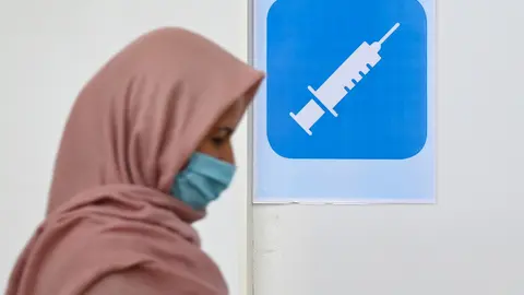 27 May 2021, Hessen, Frankfurt_Main: A woman walks into a vaccination booth at the cultural centre of the Imam Sadjad Mosque in the Fechenheim district. For three consecutive days, almost 200 people are vaccinated daily at the cultural centre. The vaccination campaign in the mosque is part of the city of Frankfurt's strategies for a high vaccination rate. Photo: Arne Dedert/dpa/POOL/dpa