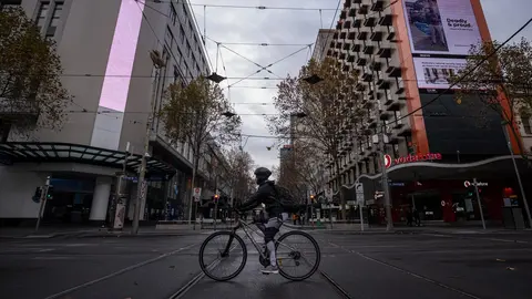 09 June 2021, Australia, Melbourne: A cyclist crosses a quiet Bourke Street. Melbourne will exit a COVID-19 lockdown as planned on Thursday night, but some restrictions on travel and gatherings would apply for another week. Photo: Daniel Pockett/AAP/dpa