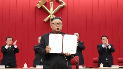 HANDOUT - 17 June 2021, North Korea, Pyongyang: A picture provided by the North Korean state news agency (KCNA) on 18 June 2021, shows North Korean leader Kim Jong-un holding up a document carrying his signature at the third plenary meeting of the eighth Central Committee of North Korea's Workers' Party on its third-day to discuss international affairs, including the Biden administration's North Korea policy. Photo: -/KCNA/dpa - ATTENTION: editorial use only and only if the credit mentioned above is referenced in full