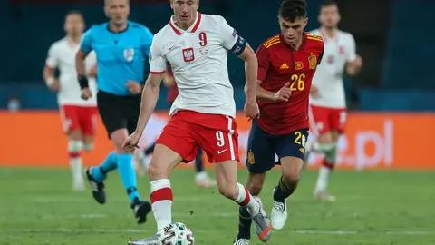 19 June 2021, Spain, Seville: Poland's Robert Lewandowski (L) and Spain's Pedri battle for the ball during the UEFA EURO 2020 Group E soccer match between Spain and Poland at La Cartuja Stadium. Photo: Cezaro De Luca/dpa