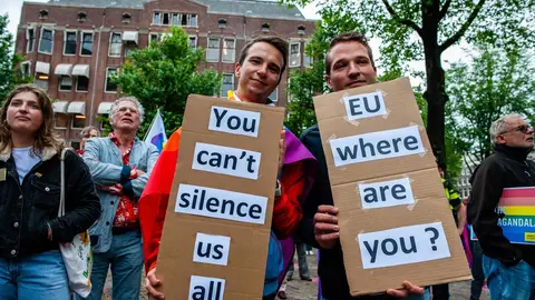 21 June 2021, Netherlands, Amsterdam: Two men hold placards asking for help to the Europe Union during a demonstration against this legislation by Hungary's parliament bans the dissemination of content in schools deemed to ˜promote homosexuality and gender change. Photo: Ana Fernandez/SOPA Images via ZUMA Wire/dpa.