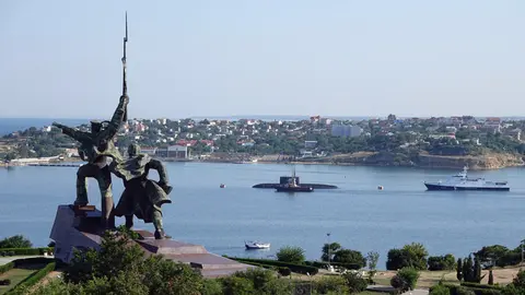 FILED - A submarine and warships of the Russian Black Sea Fleet lie at anchor in the port city of Sevastopol in 2019. The Russian military warned away a British warship with bombs and gunfire after it allegedly entered Russian territorial waters near the Crimean Peninsula on Wednesday, the TASS news agency reports. Photo: Ulf Mauder/dpa