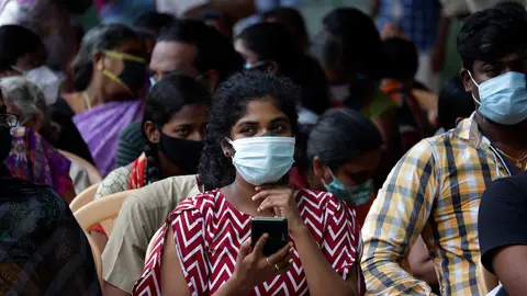 23 June 2021, India, Chennai: People wait outside a school compound with face masks to get vaccinated against coronavirus at a vaccination center using the Covaxin vaccine. Photo: Sri Loganathan/ZUMA Wire/dpa.