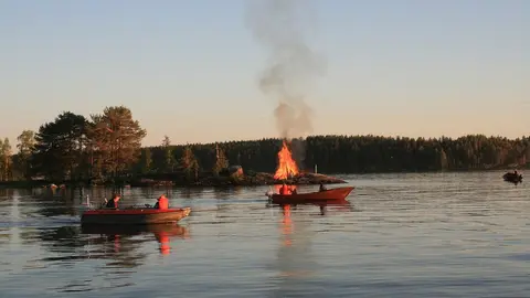 People watching a typical Midsummer bonfire in a lake. Photo: Walter Bieck/Pixabay/File photo.