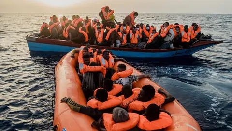 HANDOUT - 04 July 2021, Italy, ---: Migrants sit in a small boat and a rubber dinghy in the Mediterranean Sea. The Ocean Viking rescue vessel has pulled 67 people from the central Mediterranean Sea, SOS Mediterranee the private organization that runs the vessel, said on Sunday. Photo: Flavio Gasperini/SOS Mediterranee/dpa - ATTENTION: editorial use only and only if the credit mentioned above is referenced in full