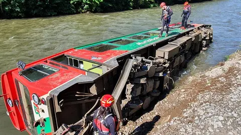 HANDOUT - 09 July 2021, Austria, Ramingstein: A carriage of a regional train lies in the Mur River after a train with dozens of children and teenagers on board derailed in Austria and plunged into a river. According to the rescue commander Anton Schilcher, 17 people were slightly injured in the accident in the province of Salzburg on Friday. Photo: Wasserrettung Lv Salzburg/WASSERRETTUNG LV SALZBURG/dpa - ATTENTION: editorial use only in connection with the latest coverage and only if the credit mentioned above is referenced in full