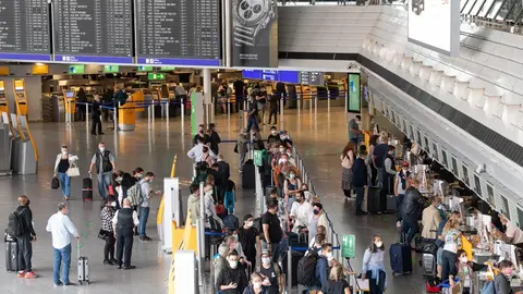 08 July 2021, Hessen, Frankfurt/Main: Passengers wait in queues at the check-in counters in Terminal 1 of Frankfurt Airport. The passenger volume at Frankfurt Airport has increased in recent weeks. Photo: Boris Roessler/dpa