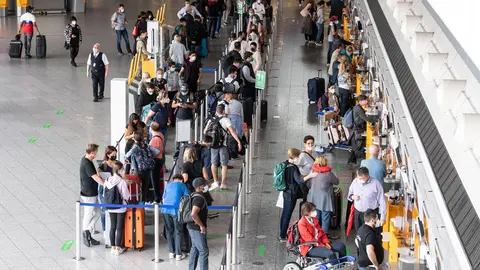 08 July 2021, Hessen, Frankfurt/Main: Passengers wait in queues at the check-in counters in Terminal 1 of Frankfurt Airport. The passenger volume at Frankfurt Airport has increased in recent weeks. Photo: Boris Roessler/dpa