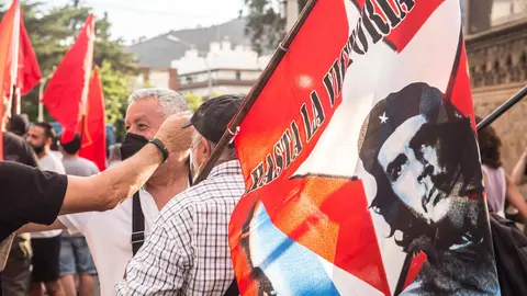 15 July 2021, Spain, Barcelona: A protester holds a flag with the face of Ernesto Che Guevara that says, until victory during a demonstration in front of the US Consulate in Barcelona against the United States blockade of Cuba and in solidarity with the Cuban peopl. Photo: Thiago Prudencio/SOPA Images via ZUMA Wire/dpa.