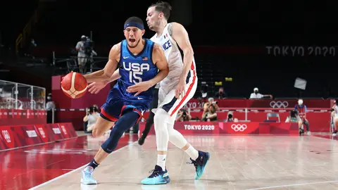 25 July 2021, Japan, Saitama: USA's Devin Booker (L) and France's Thomas Heurtel battle for the ball during the Men's Preliminary Round Group A basketball match between France and the United States at the Saitama Super Arena, held as part of the Tokyo 2020 Olympic Games. Photo: Mickael Chavet/ZUMA Press Wire/dpa