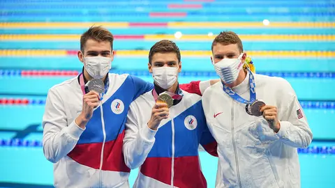27 July 2021, Japan, Tokyo: (L-R) Russian Olympic Committee silver medallist Kliment Kolesnikov, Russian Olympic Committee gold medallist Evgeny Rylov, and US bronze medallist Ryan Murphy celebrate during the medal ceremony of the Men's 100m Backstroke Final swimming event at the Tokyo Aquatics Centre, during the Tokyo 2020 Olympic Games. Photo: Michael Kappeler/dpa