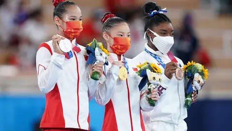 03 August 2021, Japan, Tokyo: (L-R) Silver medallist China's Xijing Tang, gold medallist China's Chenchen Guan, and bronze medallist USA's Simone Biles celebrate their medals at the award ceremony for the Women's Balance Beam Final of the Artistic Gymnastics competition at the Ariake Gymnastics Centre during the Tokyo 2020 Olympic Games. Photo: Mike Egerton/PA Wire/dpa