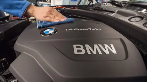 FILED - 13 March 2015, Bavaria, Regensburg: A staff member polishes the engine of a BMW car model at the assembly plant of car manufacturer BMW in Regensburg. The international shortage of microchips means German carmaker BMW will temporarily stop production at its facility in Regensburg, according to a company spokesperson on Sunday. Photo: picture alliance / dpa