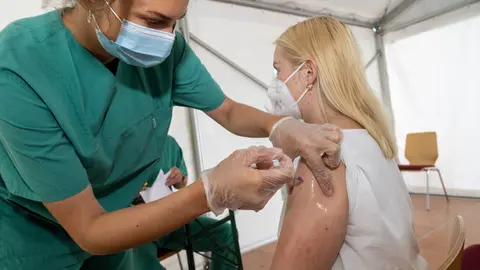 02 August 2021, Mecklenburg-West Pomerania, Lubmin: Anastasia Grawe gets vaccinated against the coronavirus by a medical employee in a tent of the municipality on the beach in the district of Vorpommern-Greifswald. Photo: Stefan Sauer/dpa