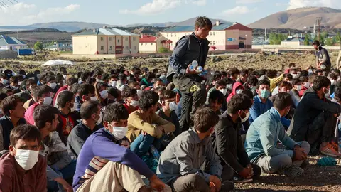 03 August 2021, Turkey, Caldiran: About 400 refugees from Afghanistan, Pakistan and Iran, picked up by Turkish police, wait at a checkpoint near the city of Caldiran, close to Turkey's border with Iran. About 300 of them were found crammed into a truck. Photo: Bradley Secker/dpa