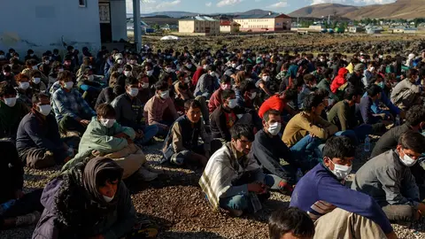 03 August 2021, Turkey, Caldiran: About 400 refugees from Afghanistan, Pakistan and Iran, picked up by Turkish police, wait at a checkpoint near the city of Caldiran, close to Turkey's border with Iran. About 300 of them were found crammed into a truck. Photo: Bradley Secker/dpa