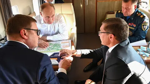 HANDOUT - Russian President Vladimir Putin (C) meets with (L-R) Governor of the Chelyabinsk Region Alexei Teksler, Plenipotentiary Representative of the President in the Urals Federal District Vladimir Yakushev and Head of the Ministry of Emergency Situations Yevgeny Zinichev while flying around the regions of the Chelyabinsk Region affected by fires. Photo: -/Kremlin/dpa - ATTENTION: editorial use only and only if the credit mentioned above is referenced in full.