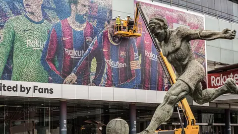 10 August 2021, Spain, Barcelona: Workers on a crane remove a poster of Argentine footballer Lionel Messi from the facade of the Camp Nou Stadium after his departure from the club. Photo: Thiago Prudencio/SOPA Images via ZUMA Press Wire/dpa