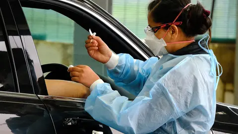 09 August 2021, Australia, Melbourne: A health worker inoculates a diver with a jab of coronavirus vaccine at a drive-through COVID-19 vaccine hub. Victoria has entered a seven-day lockdown to contain a growing outbreak of the Delta variant of COVID-19 in the Australian state. Photo: Luis Ascui/AAP/dpa