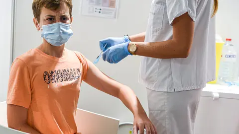 16 August 2021, Spain, Valencia: A health worker administers a dose of Covid-19 vaccine to a teenager at a vaccination centre in the City of Arts in Valencia. Photo: Jorge Gil/EUROPA PRESS/dpa
