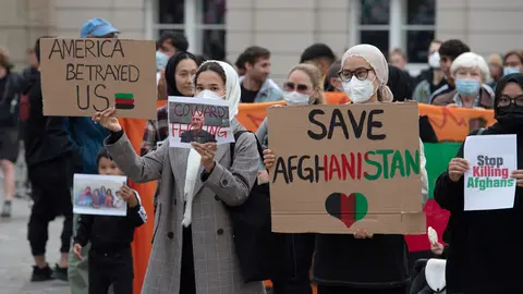 17 August 2021, Brandenburg, Potsdam: People stand with placards on the Old Market Square during the rally "Humanitarian Airlift Now - Don't Abandon Afghanistan's People". Photo: Paul Zinken/dpa