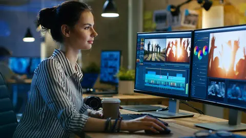 A worker doing video editing tasks with a computer in her office. Photo: Pixabay.