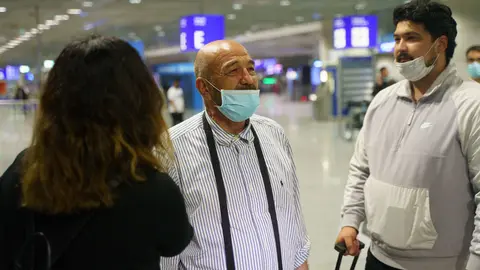 19 August 2021, Hessen, Frankfurt_Main: A man (C) who arrived from Kabul stands at Frankfurt airport early this morning. More people brought to safety from Afghanistan arrived on a Lufthansa plane that had taken off from the Uzbek capital Tashkent. Photo: Frank Rumpenhorst/dpa