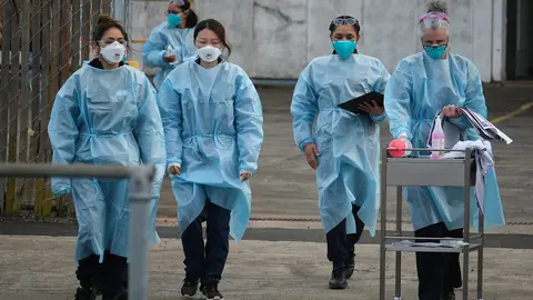23 August 2021, Australia, Melbourne: Health workers arrive at a drive-through COVID-19 Vaccination Centre in the suburb of Campbellfield. Victoria has recorded 71 new locally-acquired coronavirus cases, of which 49 are linked to known outbreaks. Photo: Luis Ascui/AAP/dpa