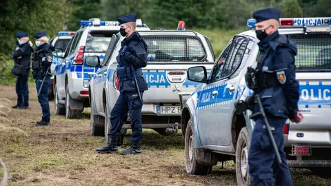 01 September 2021, Poland, Usnarz Gorny: Police officers stand on guard next to the village of Usnarz Gorny near a makeshift camp where a group of migrants stay and are not being let into the Polish side. The Polish government is introducing a State of Emergency on the border with Belarus in two voivodeships (the highest-level administrative division of Poland) to stop migrants crossing illegally. Photo: Attila Husejnow/SOPA Images via ZUMA Press Wire/dpa