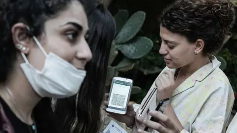 18 August 2021, Israel, Abu Gosh: Wedding guests present a green passport from the Health Ministry based on a smartphone app before entering. The government has imposed new restrictions as Israel battles the fourth wave of coronavirus, which is predominantly of the delta variety. The green passport will only be issued to people who are fully vaccinated or have recovered from a corona infection. Photo: Nir Alon/ZUMA Press Wire/dpa